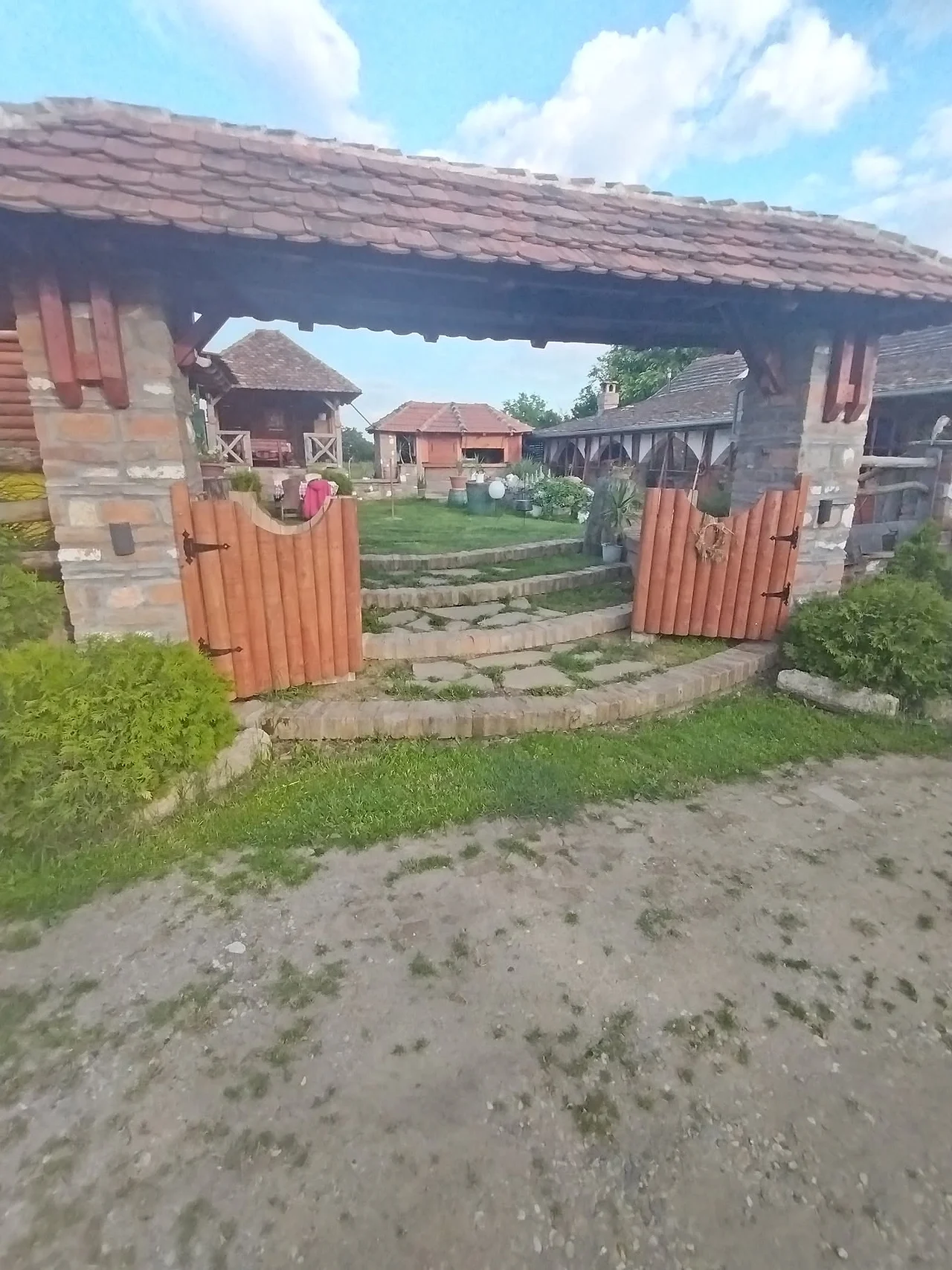Dvorište sa drvenim brvnarama i kapijom