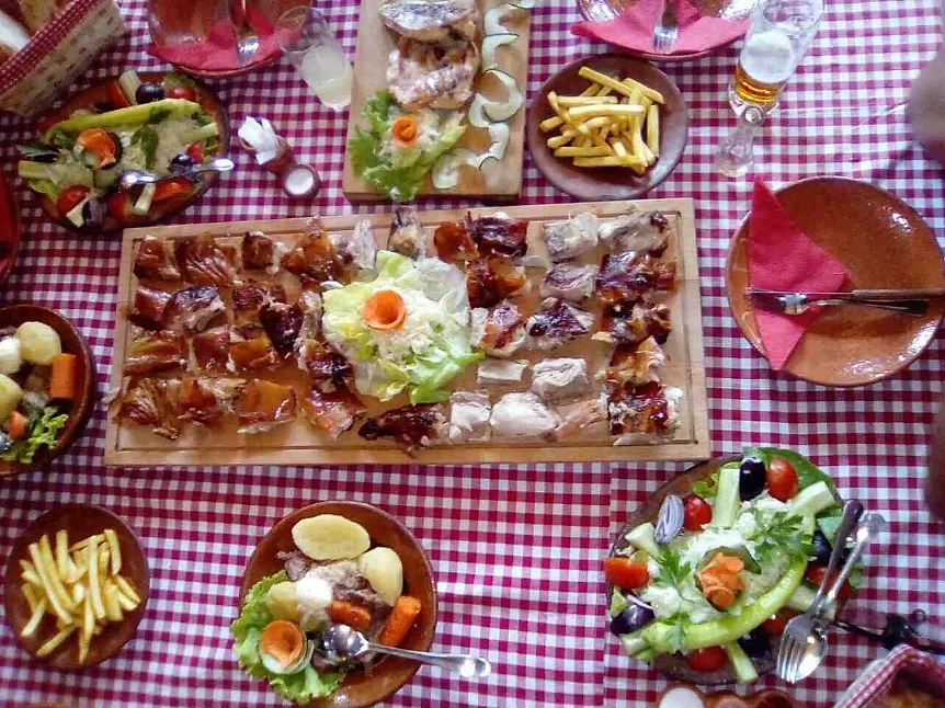 Bogata domaća trpeza sa pečenjem, salatama i prilozima